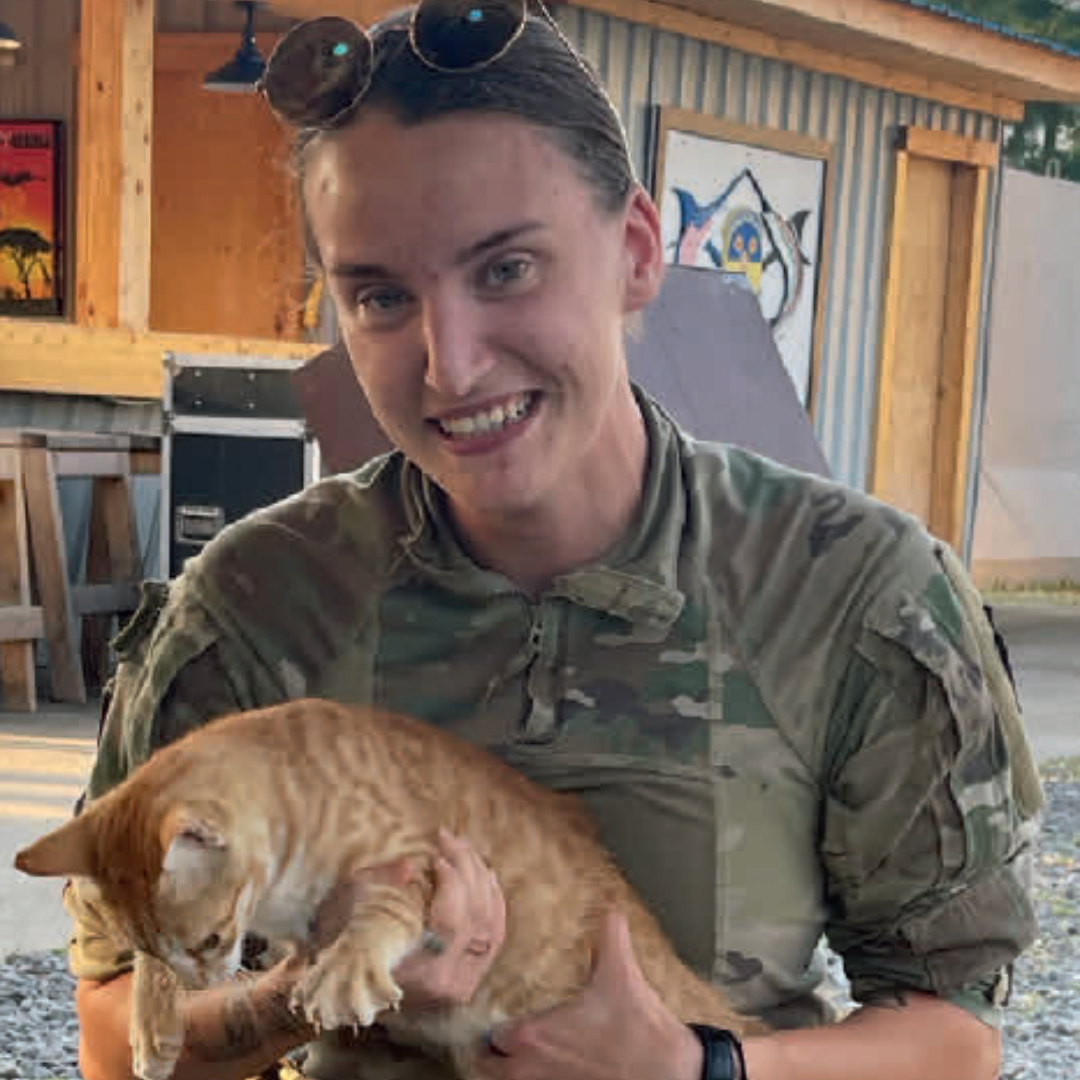 TJ Smith in military gear while holding a cat.