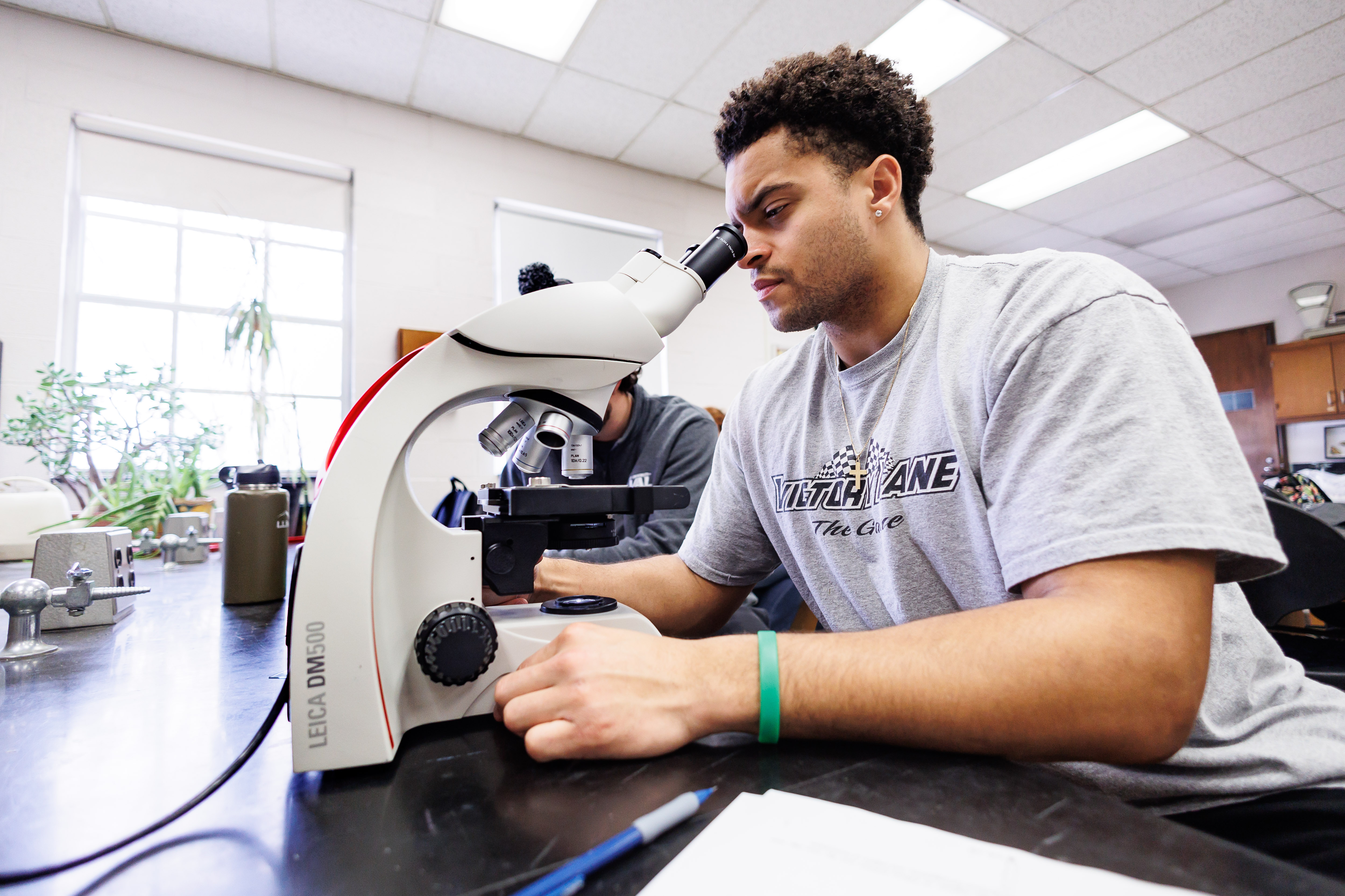 A student is looking through a microscope.
