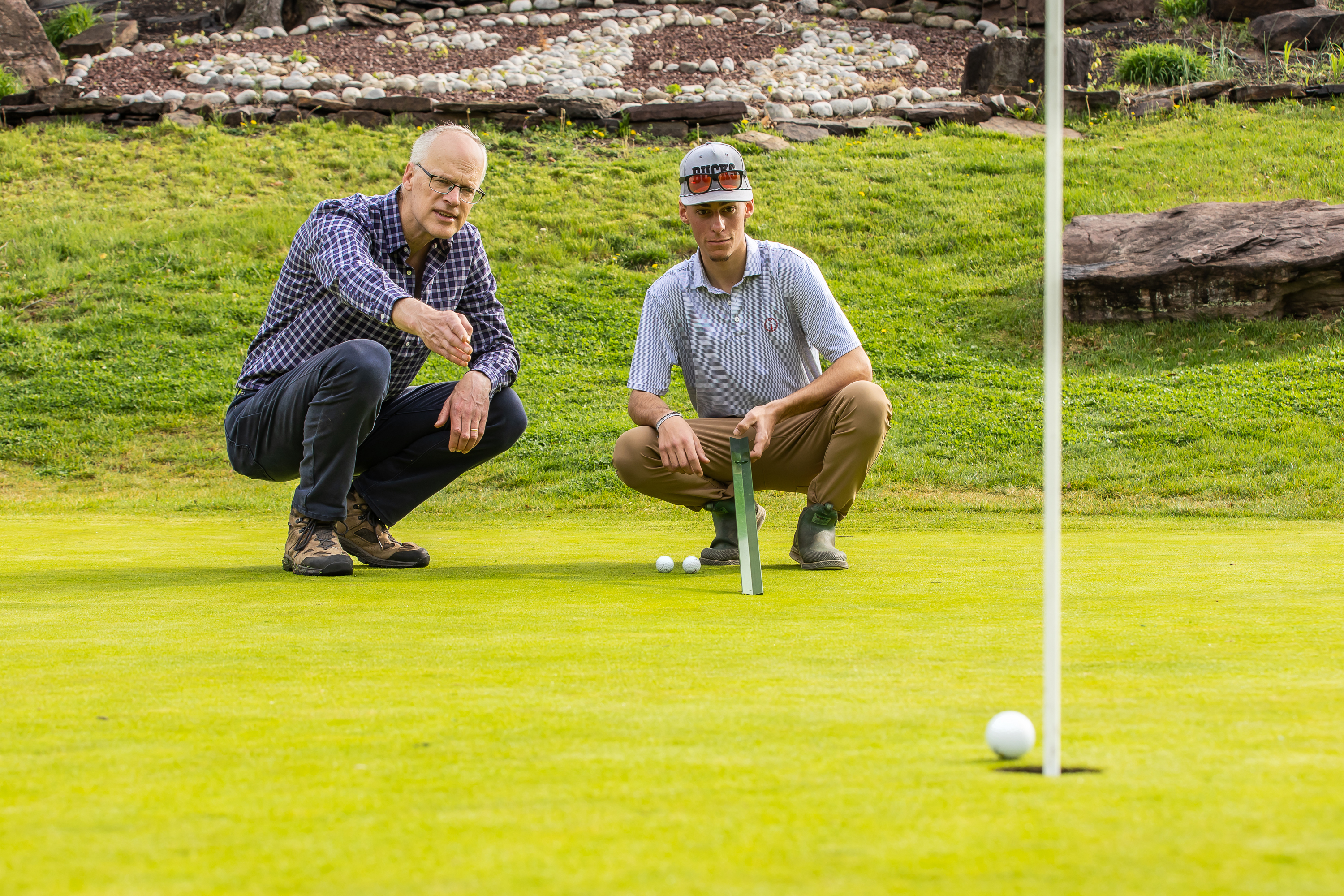 Turf professor, doug linde is working with one student on a golf course.