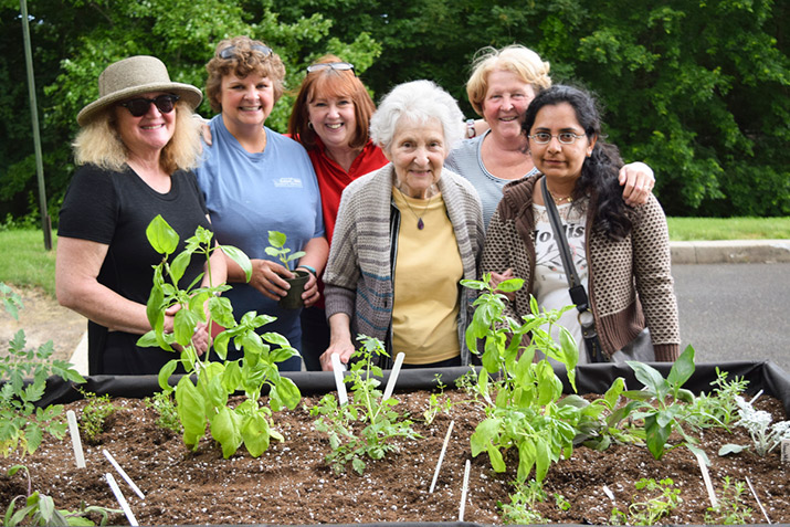 horticultural therapy program students at Lakeview with staff and a resident in front of a raised garden bed