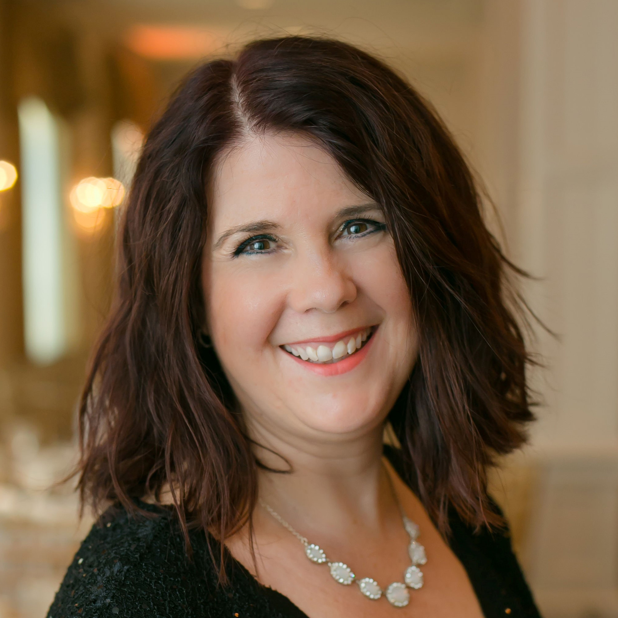 April Donahue is smiling at the camera for an upclose headshot.