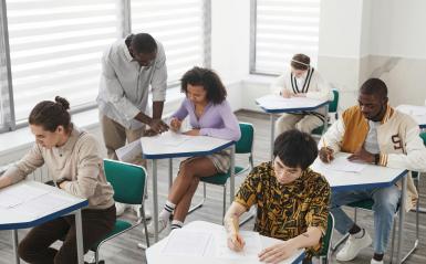 High school students working in class with a teacher. 