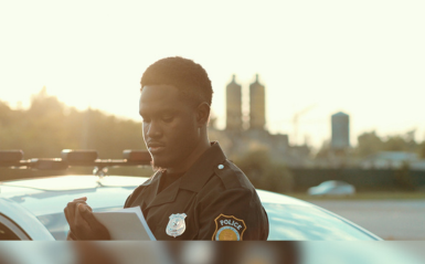 A cop is writing on a notepad dressed in uniform.