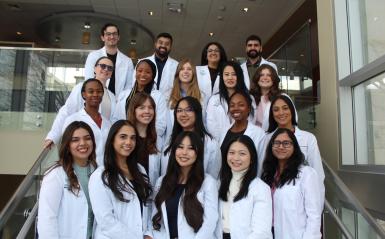 PA students are standing on the steps in LSB in their white coats. 