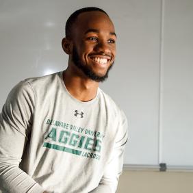 Khalil Lindsey smiling and wearing an Aggies shirt.