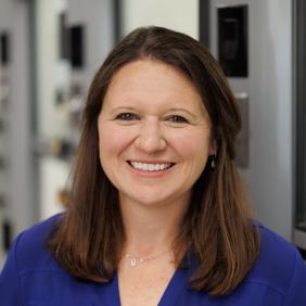 Melissa Langston in the lab for a headshot wearing a blue collared shirt. 