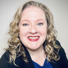 Jennifer White Yeatts Headshot in a black blazer and blue shirt. 