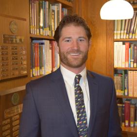 A photo of Thomas O'connor standing in the library at DelVal.