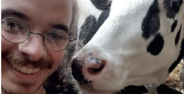 Derric Smith with a cow on campus