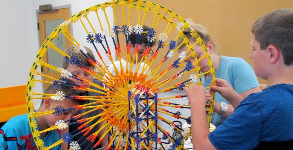 Kids in STEAM are building a miniature ferris wheel. 