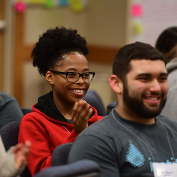A group of students listens to a speaker discuss leadership.
