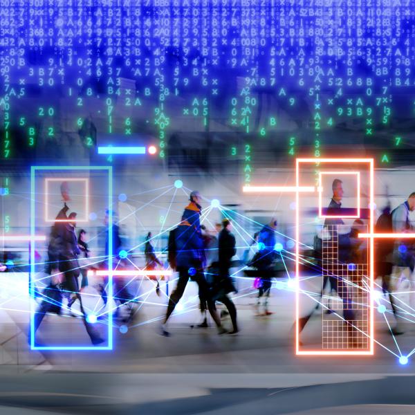 Business people are walking in a coporate setting, technological icons hover the heads of the people. 