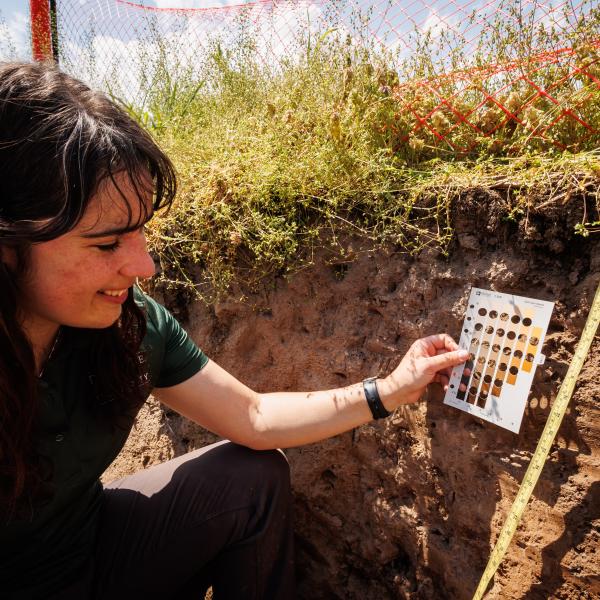Jaclyn Fiola is in a pit of soil, testing coloration and measurement of the pit. 