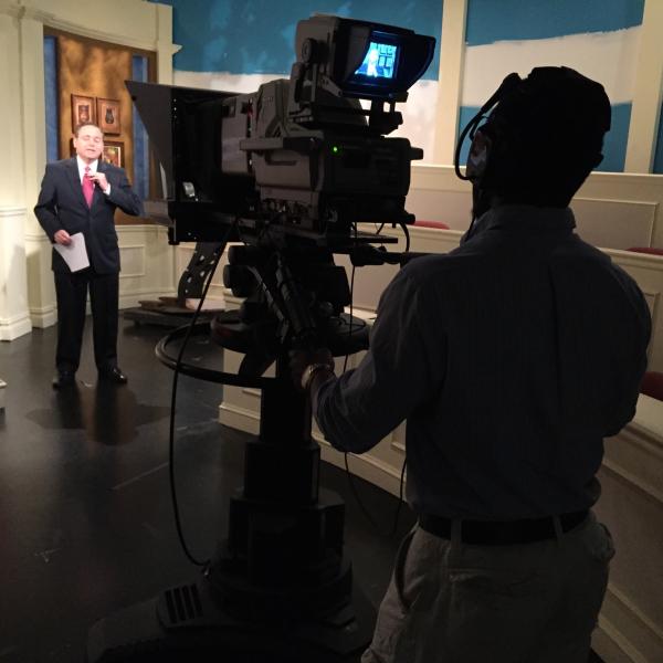 A student is filming a business leader. 