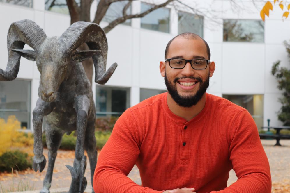 Student smiling in front of ram statue