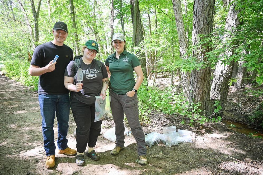 Jaclyn standing with students in the forestation of delval. 