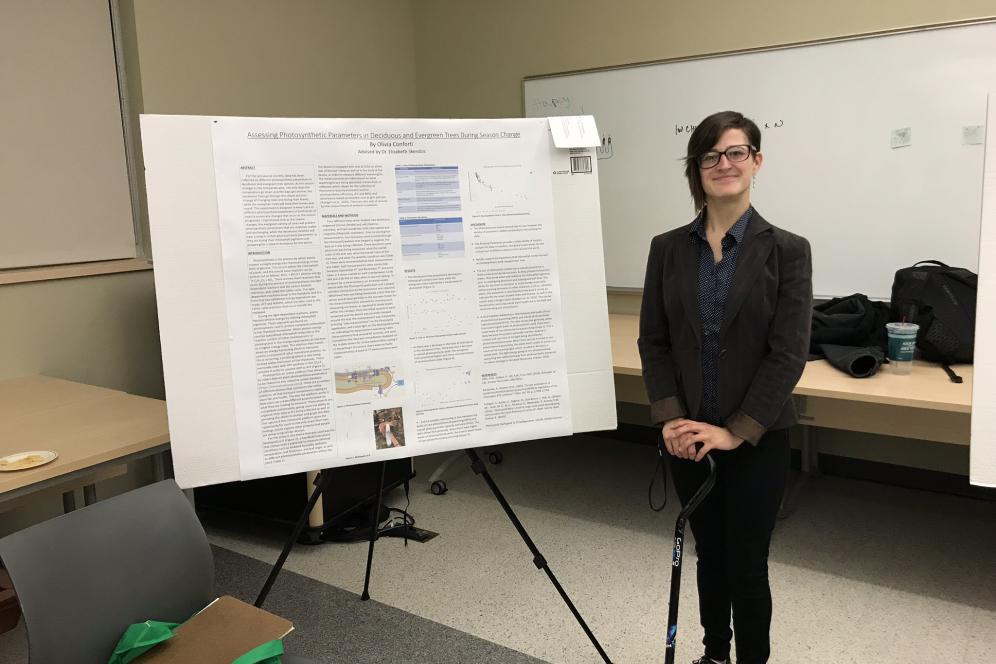 Olivia Conforti, a student, is standing beside her research poster.