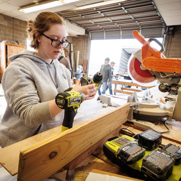 A female DelVal student working on a Flower Show display. 