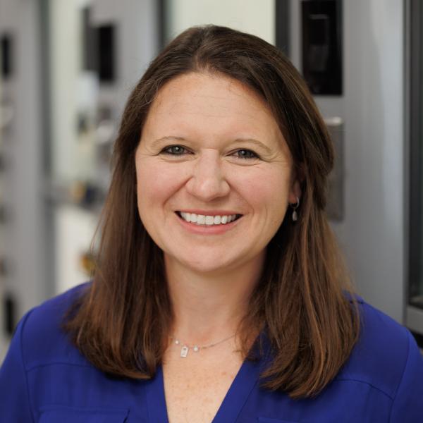 Headshot of Melissa Langston in the lab, with a blue button down shirt. 
