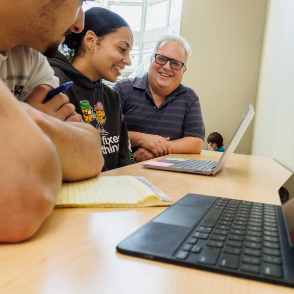 Lance Hill with Students in the Life Science Building working on a computer.