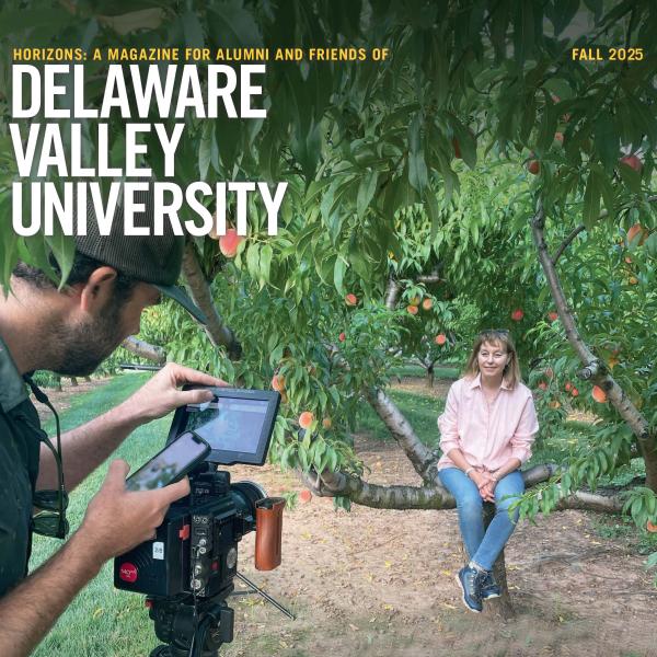 Cover of Horizons magazine 2025, featuring Jackie Ricotta sitting on a tree branch in front of a camera.