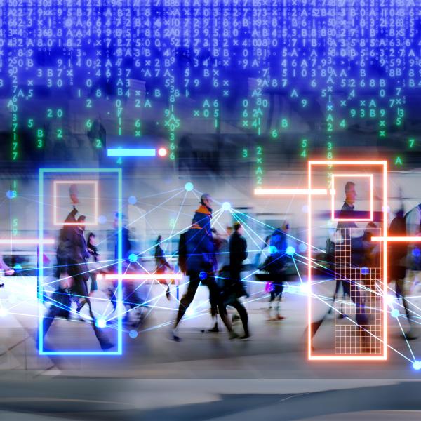 Business people are walking in a coporate setting, technological icons hover the heads of the people. 