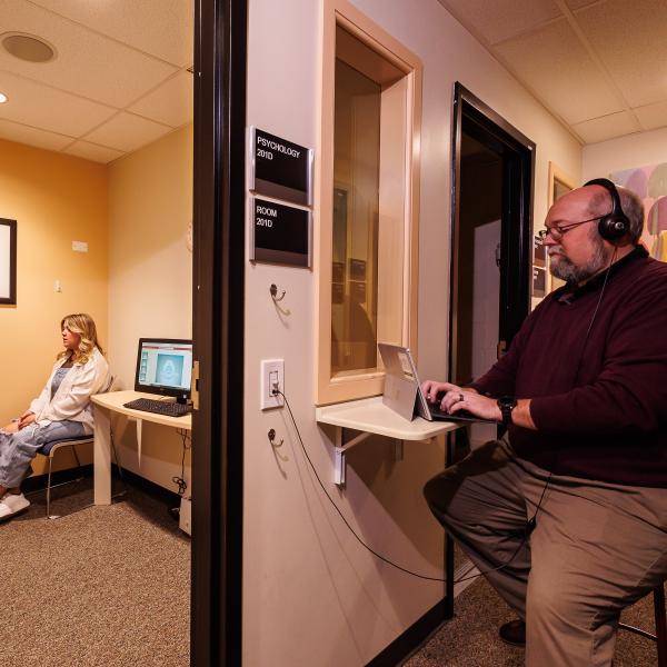Two students and a professor are in a counseling psychology lab. 