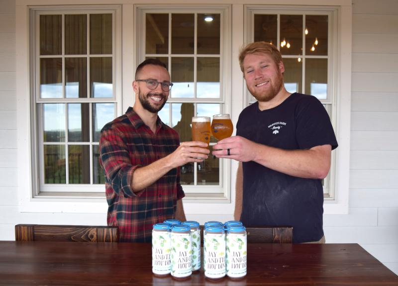 Chris Gambino and Ryan Seiz hold beer glasses and toast. 
