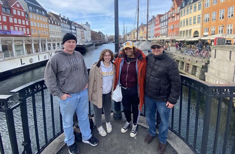 Students in Denmark in front of colorful buildings. 