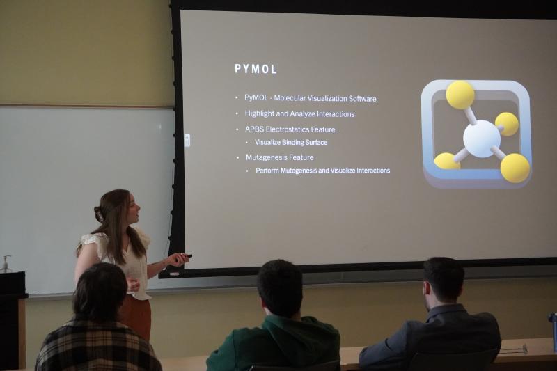 A student is in a classroom presenting a slideshow. 