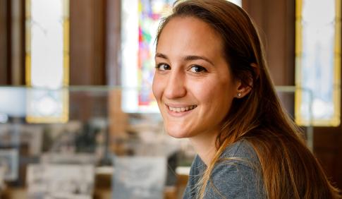 A smiling female student in a library. 