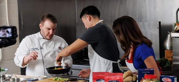 a student and a chef are making a dish in the food science lab