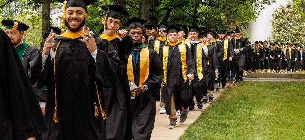 Students are lined up in cap and gown for commencement. 