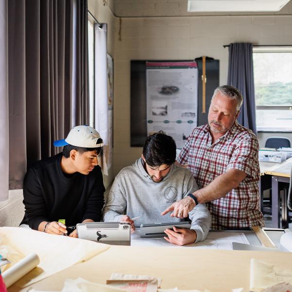 Two students are working with a professor in the landscape architecture studio.